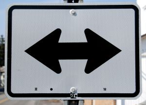Street sign with arrows pointing in opposite directions