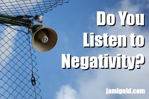 Megaphone on a security fence with text: Do You Listen to Negativity?