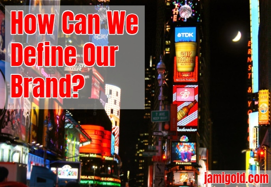 View of neon ads on Times Square at night with text: How Can We Define Our Brand?