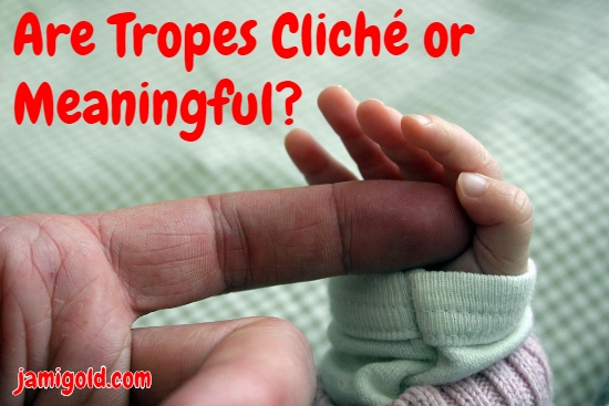 Newborn hand touching adult finger with text: Are Tropes Cliché or Meaningful?